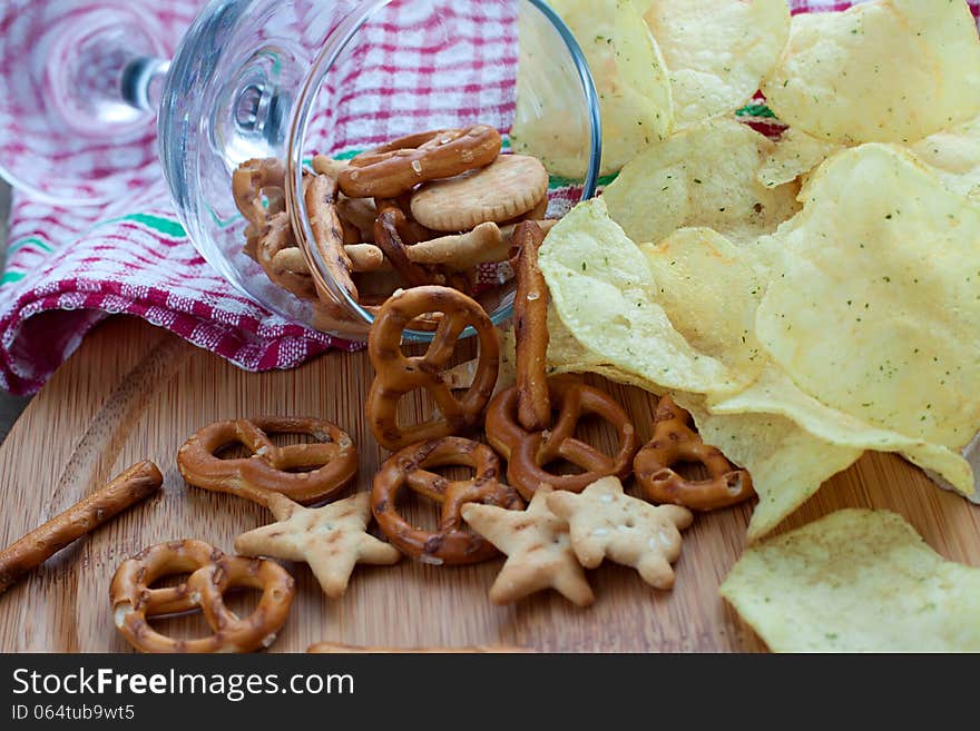 Crackers and potatoes are scattered from the glass on the table. Crackers and potatoes are scattered from the glass on the table