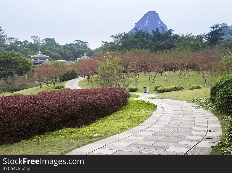 Garden view, There are trees and flowers everywhere, Chinese buildings and distant peaks.Longtan Park in Liuzhou,China. Garden view, There are trees and flowers everywhere, Chinese buildings and distant peaks.Longtan Park in Liuzhou,China.