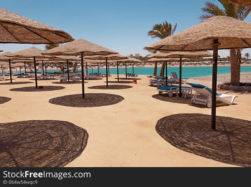 Beach with chaise lounges and sunshades. Beach with chaise lounges and sunshades