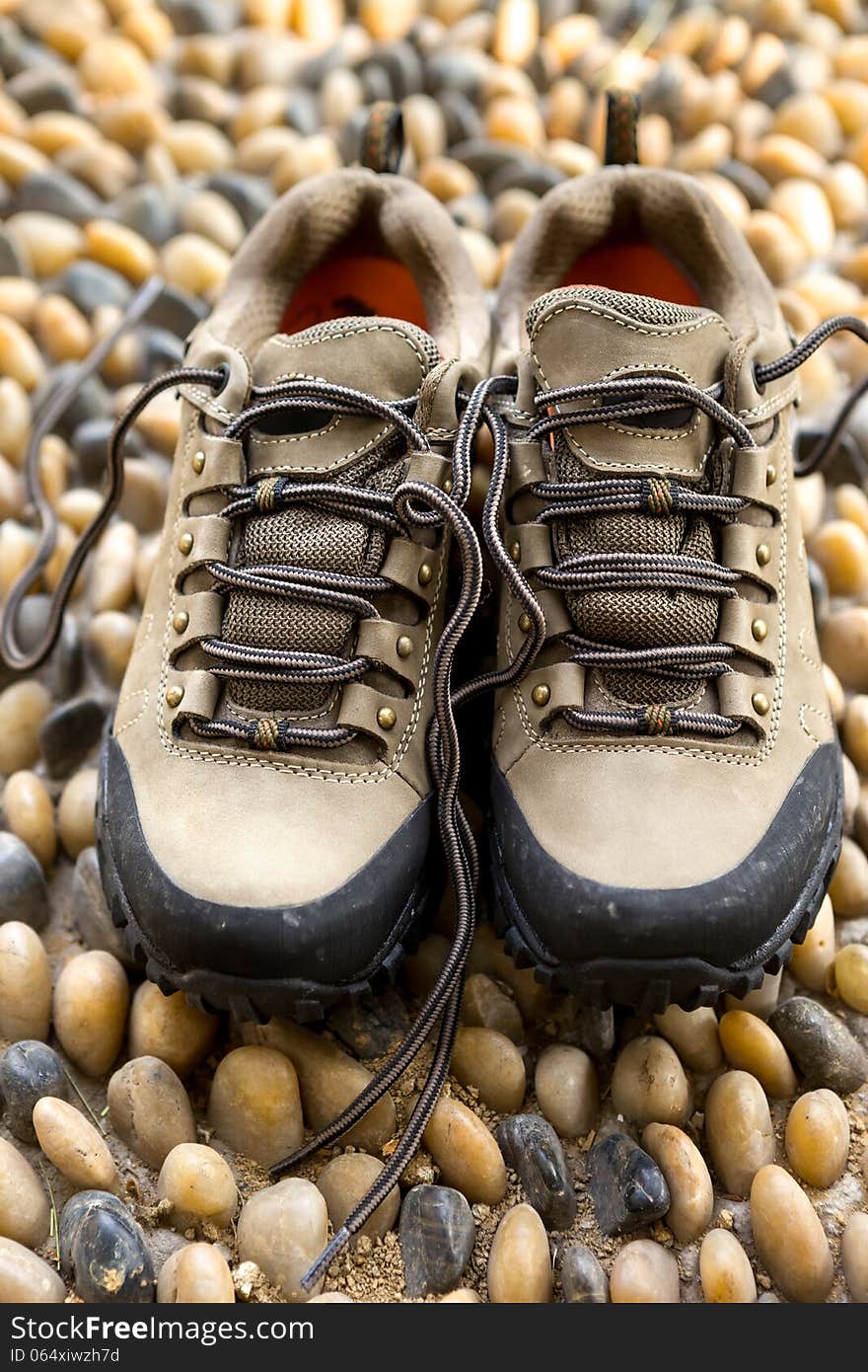 A pair of hiking shoes on cobble floor. A pair of hiking shoes on cobble floor