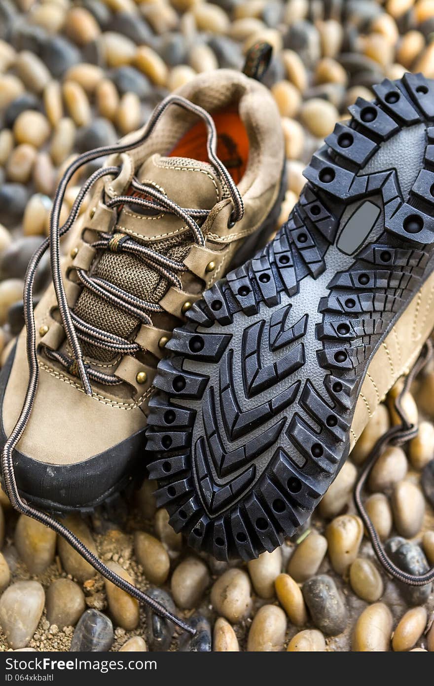 A pair of hiking shoes on cobble floor. A pair of hiking shoes on cobble floor