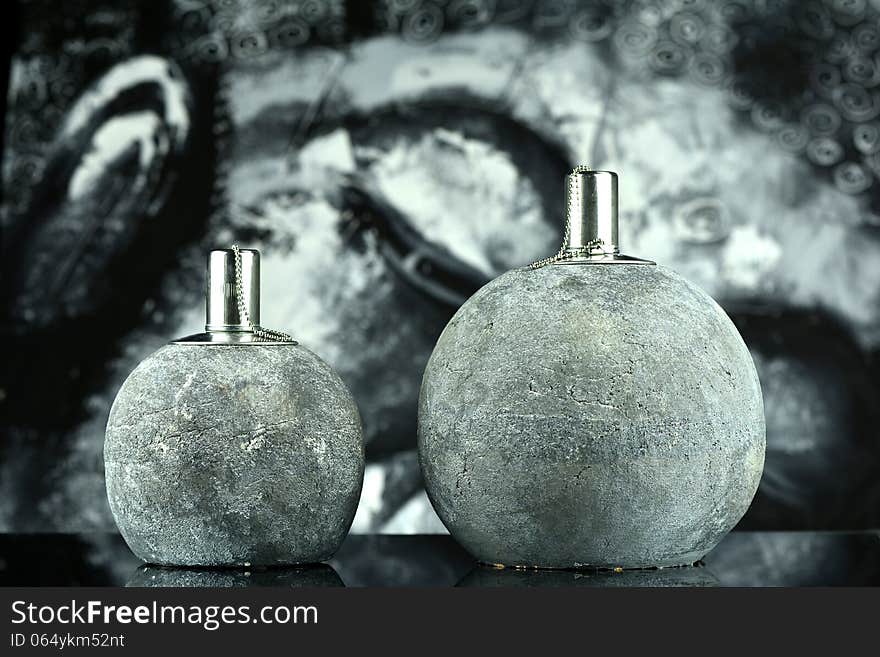 Two oil lamps that burn with a lovely flame, in the background a picture of a Buddha