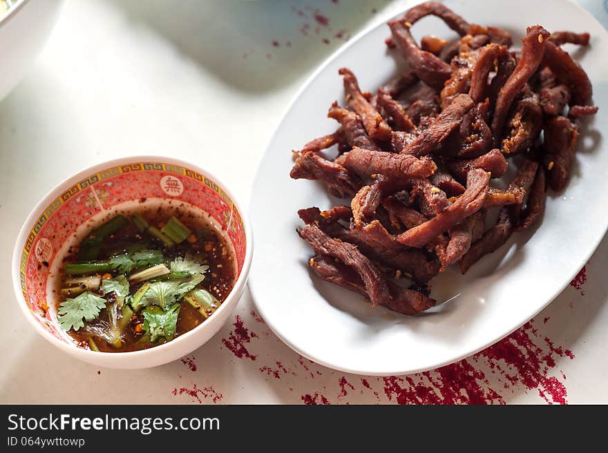 Fried pork and sauce on table .