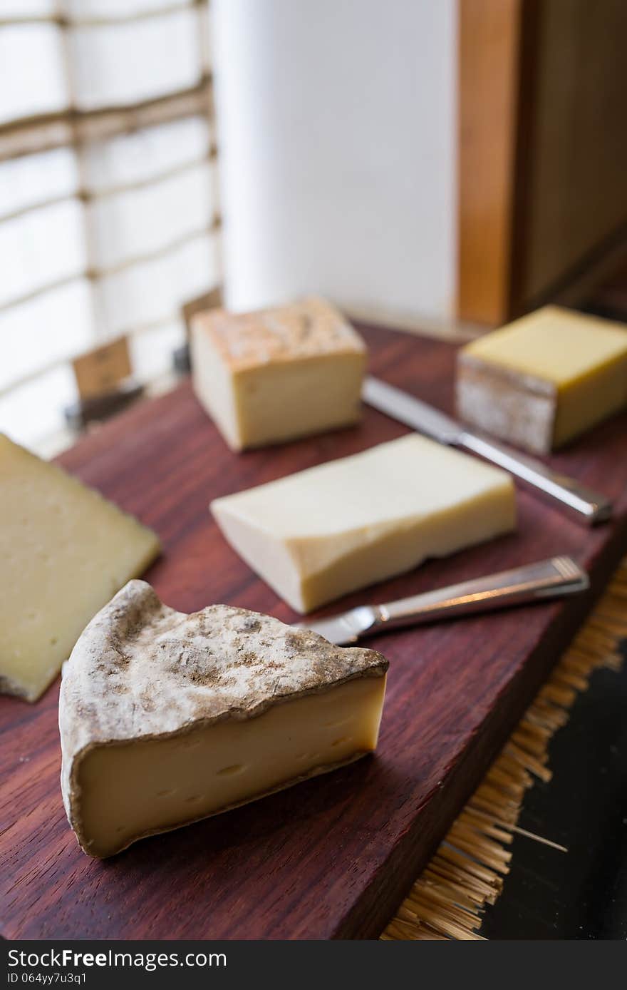 Variety of cheese on wooden board buffet line