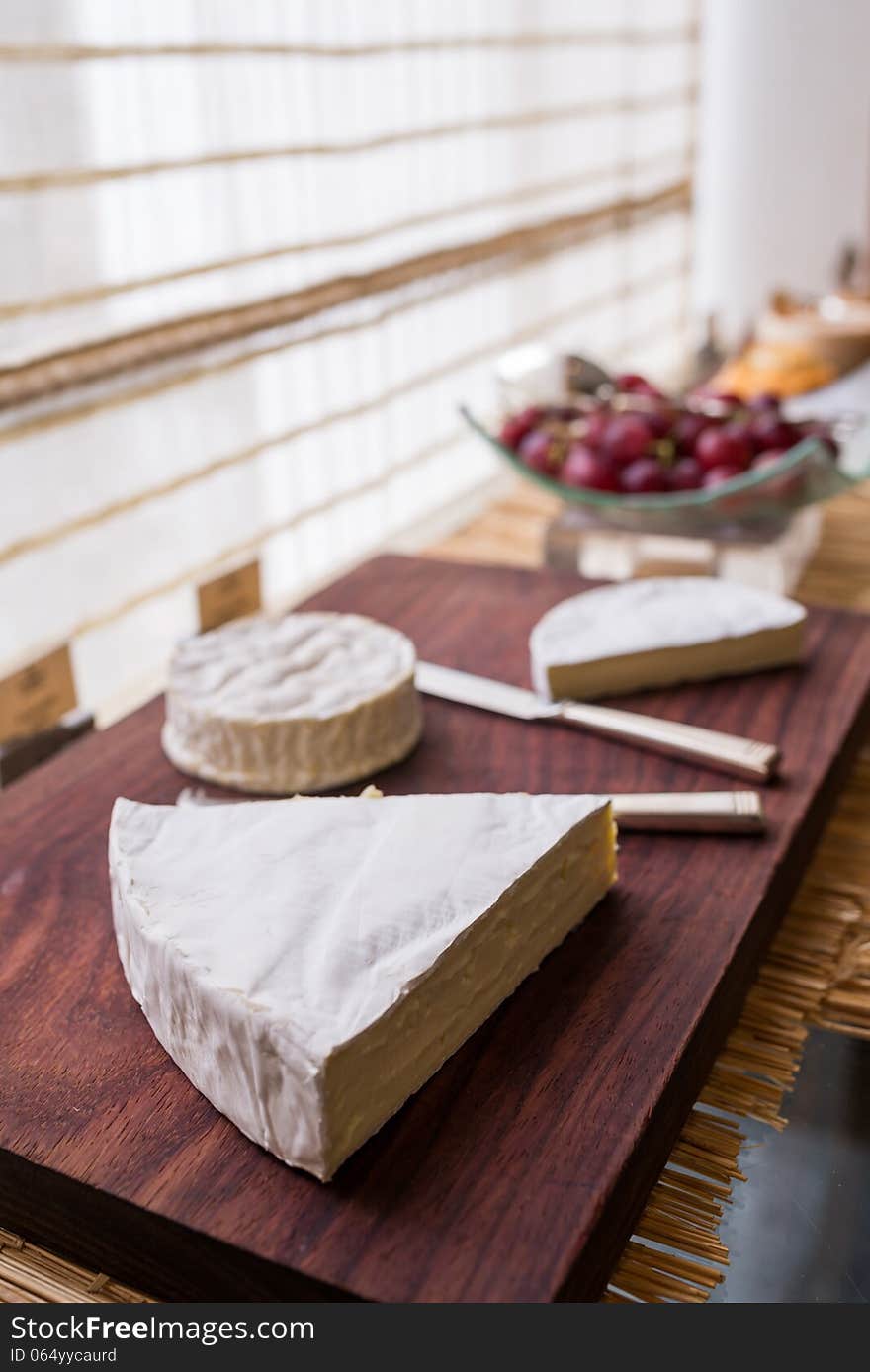 Variety of cheese on wooden board buffet line