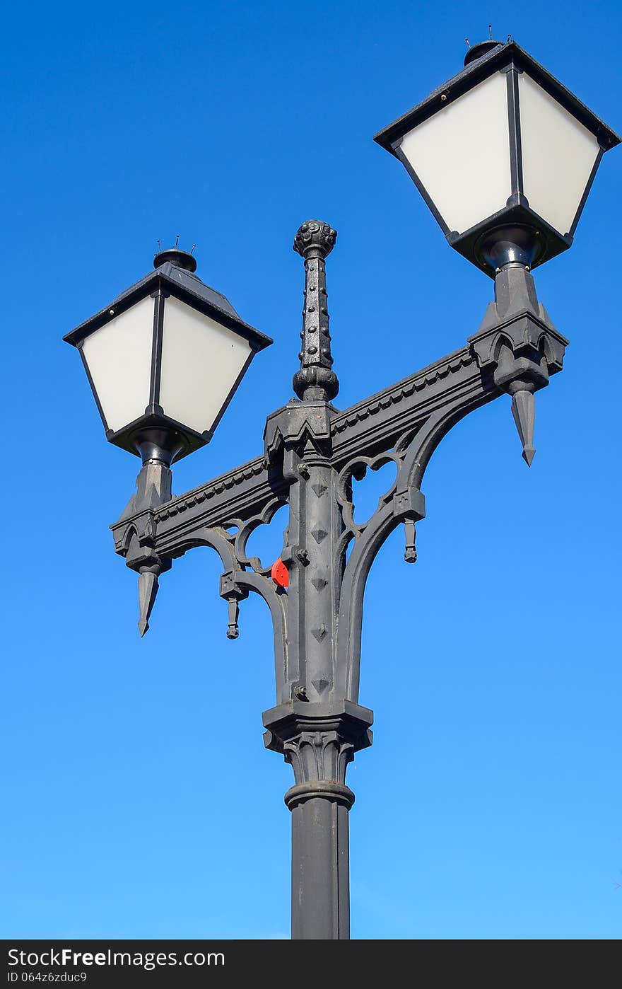 Metal street lamp against the blue sky