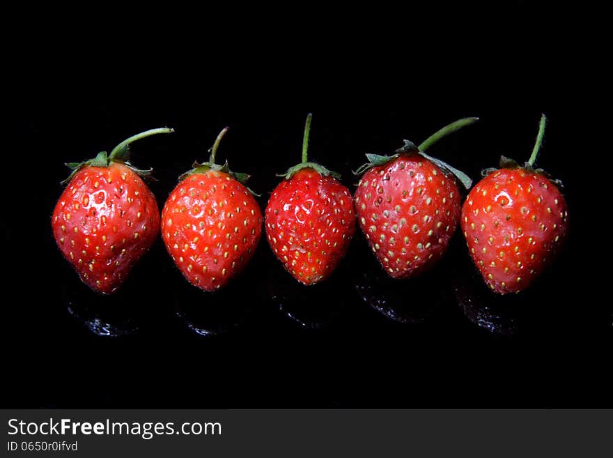 A bowl of strawberry, over black background