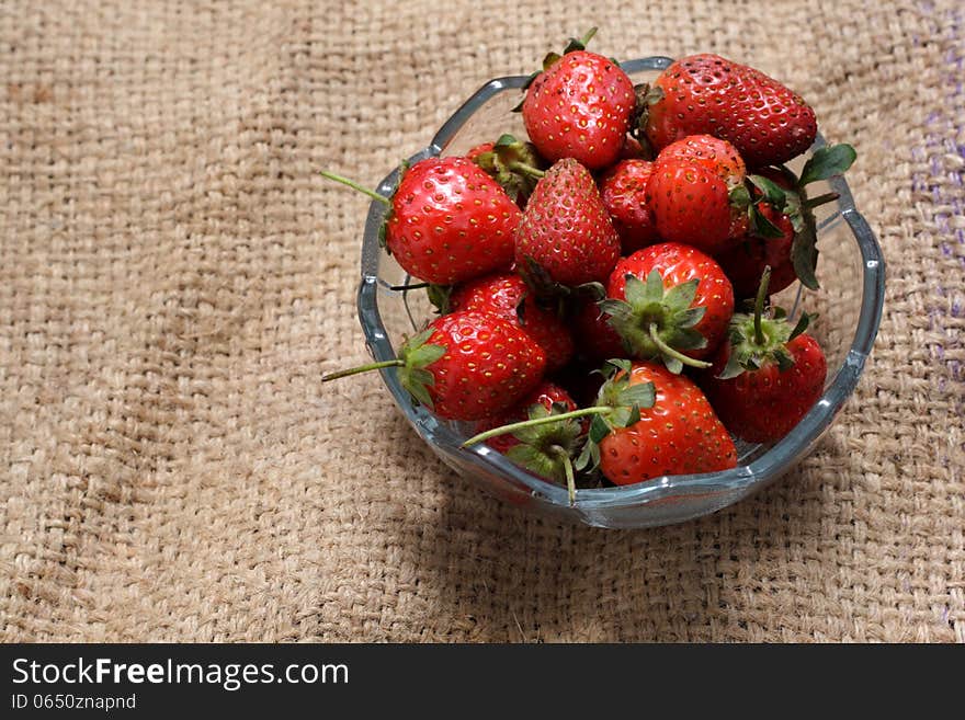 A bowl of strawberry, at natural sack cloth