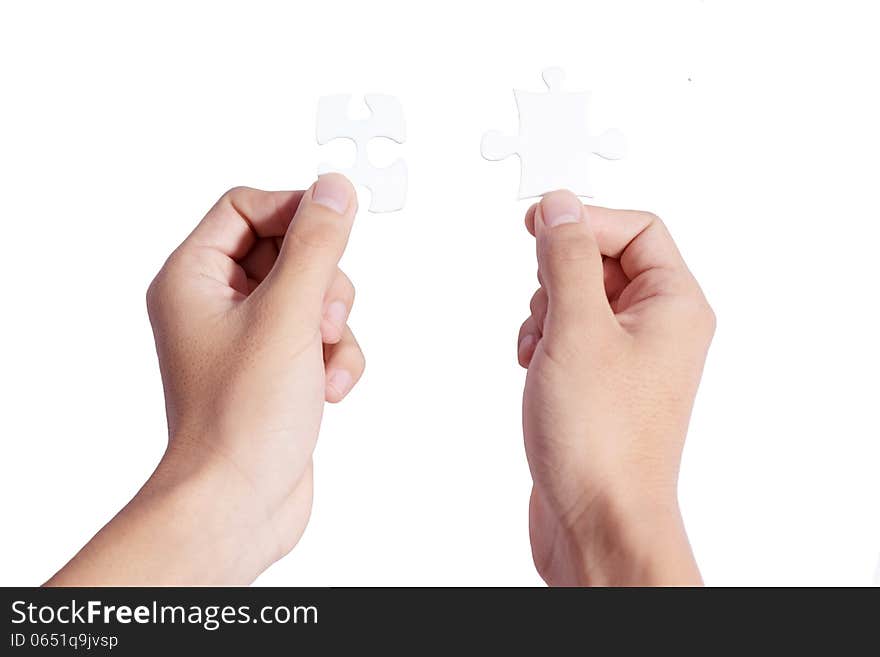 Two hands holding puzzle pieces and connecting them. Two hands holding puzzle pieces and connecting them