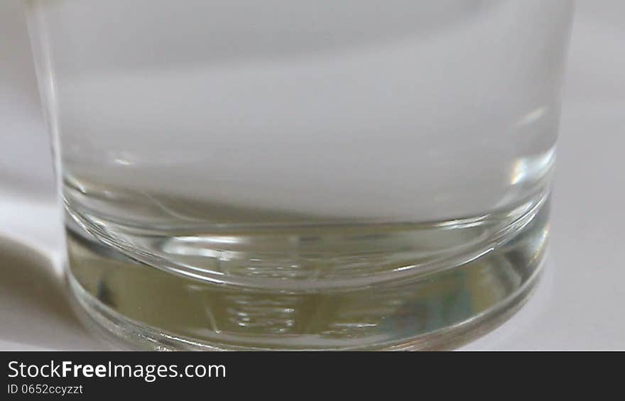 Clip of an effervescent pill being dropped in a glass of water.