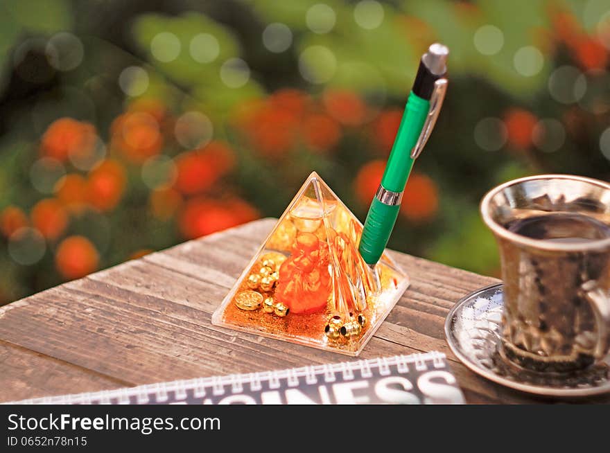 Table outdoors with a pen, cup and Hotei. Table outdoors with a pen, cup and Hotei