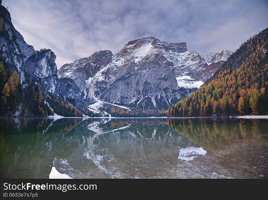 Idyllic lake surrounded by colourful forest in the Italian Alps during autumn morning. Idyllic lake surrounded by colourful forest in the Italian Alps during autumn morning.