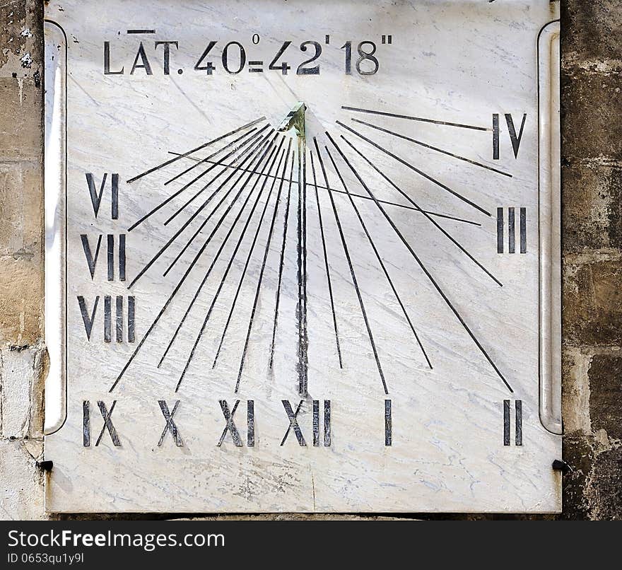 Ancient sundial on the wall a bell tower - Italy