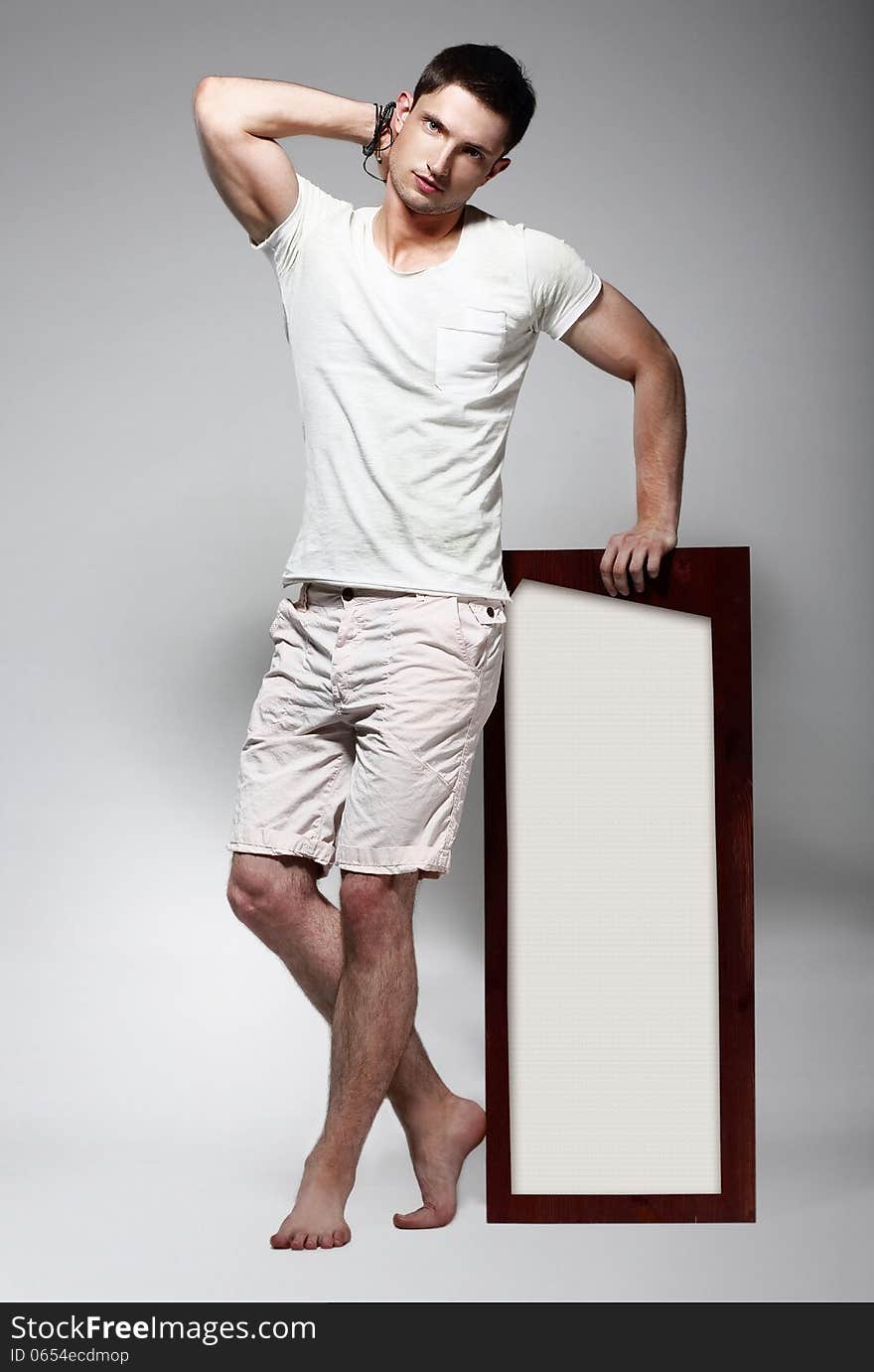 Elegant Young Man in White Cotton Clothes with Board Standing