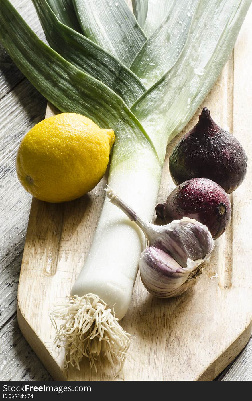 Fresh onion, garlic and lemon on a wooden cutting board. From series Healthy Eating