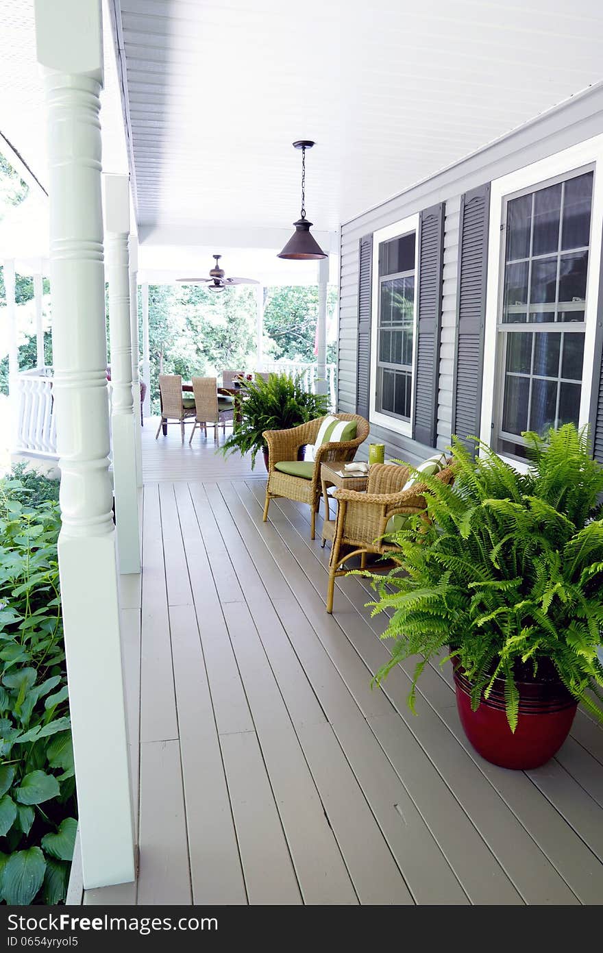 Country living is a casual affair under a veranda with classic wicker furnishings and lush potted ferns. Country living is a casual affair under a veranda with classic wicker furnishings and lush potted ferns.