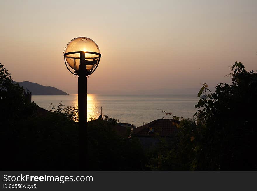 Sunset Over Sea With Light Bulb Over The Sun