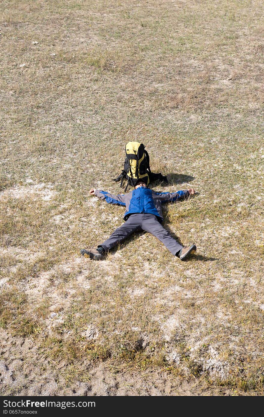 Hiker resting on the grass in autumn sunlight. Hiker resting on the grass in autumn sunlight