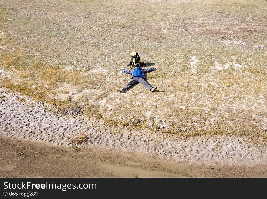 Hiker resting on the grass in autumn sunlight. Hiker resting on the grass in autumn sunlight