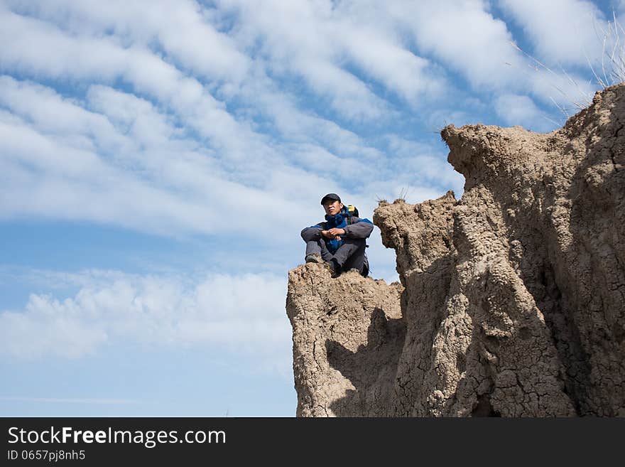 Sitting on a cliff resting hikers. Asian Youth. Sitting on a cliff resting hikers. Asian Youth