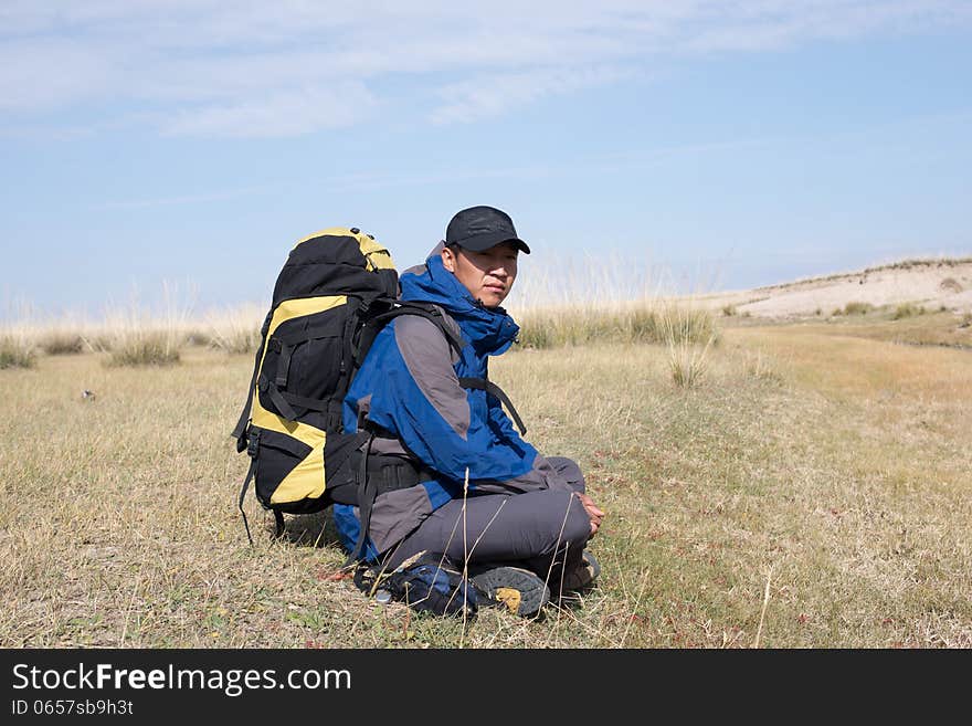 Hiker resting on the grass in autumn sunlight. Hiker resting on the grass in autumn sunlight