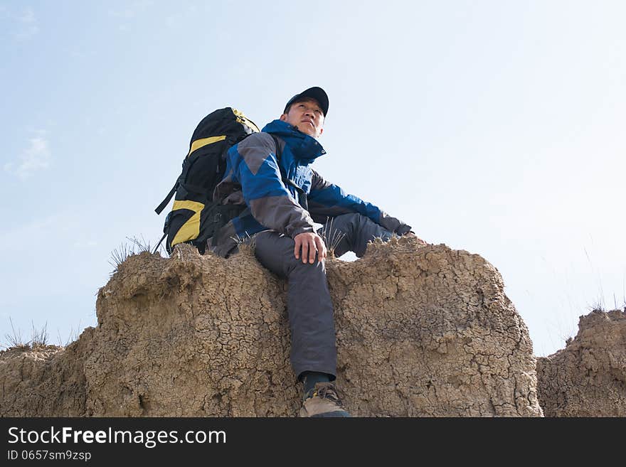 Sitting on a cliff resting hikers. Asian Youth. Sitting on a cliff resting hikers. Asian Youth