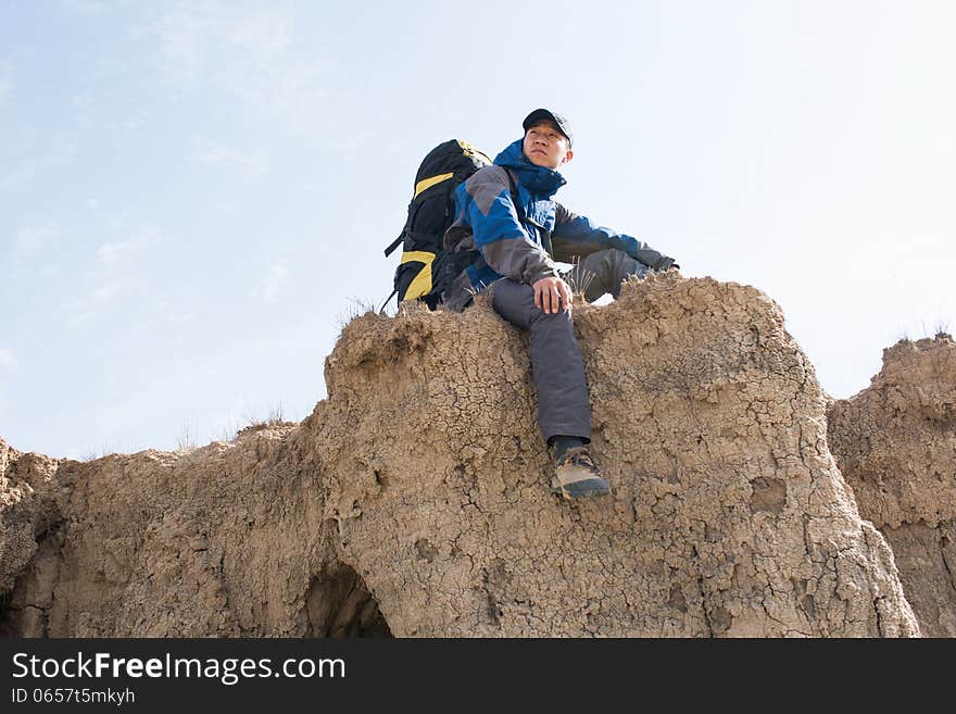 Sitting on a cliff resting hikers. Asian Youth. Sitting on a cliff resting hikers. Asian Youth