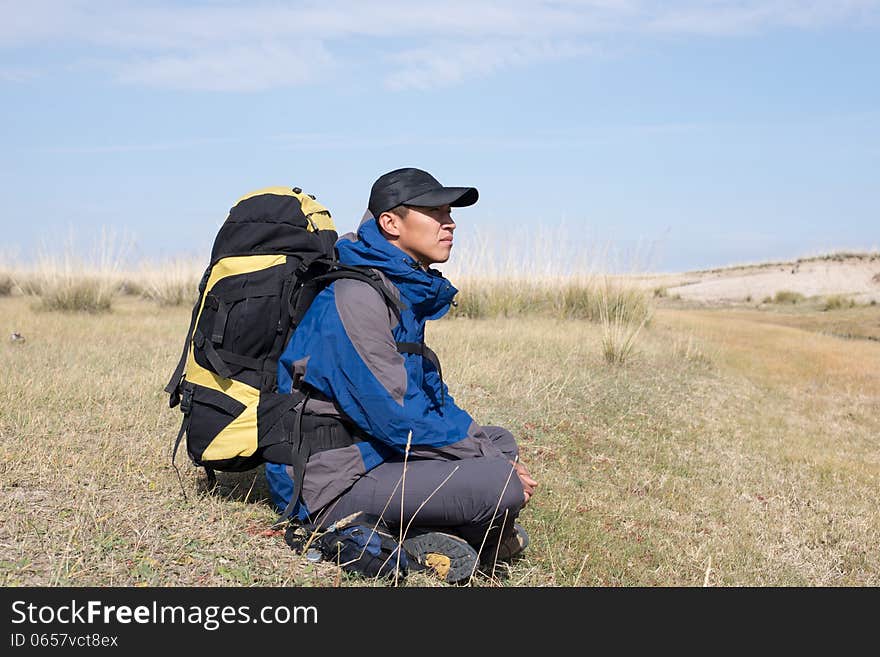 Hiker resting on the grass in autumn sunlight. Hiker resting on the grass in autumn sunlight