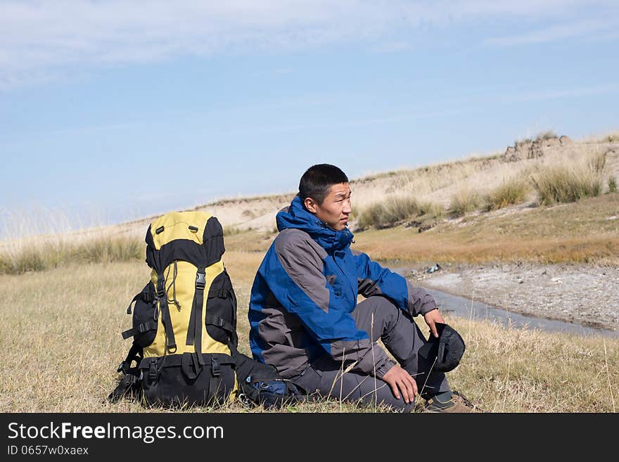 Hiker resting on the grass in autumn sunlight. Hiker resting on the grass in autumn sunlight