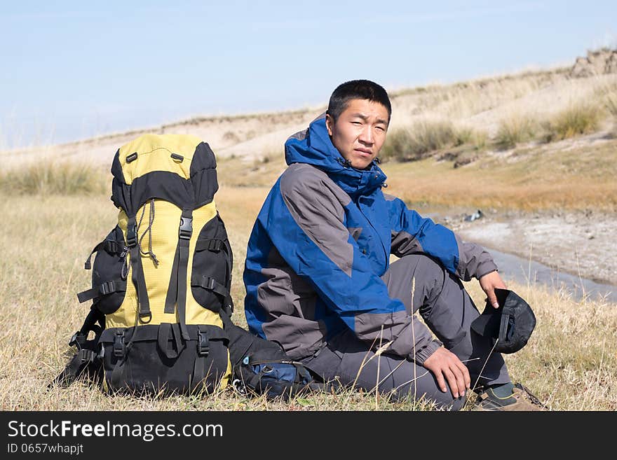 Hiker resting on the grass in autumn sunlight. Hiker resting on the grass in autumn sunlight