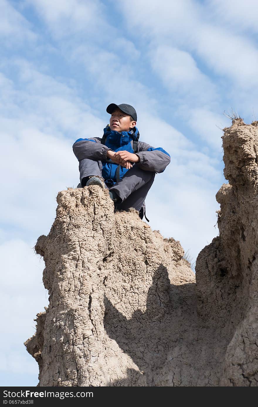 Sitting on a cliff resting hikers. Asian Youth. Sitting on a cliff resting hikers. Asian Youth