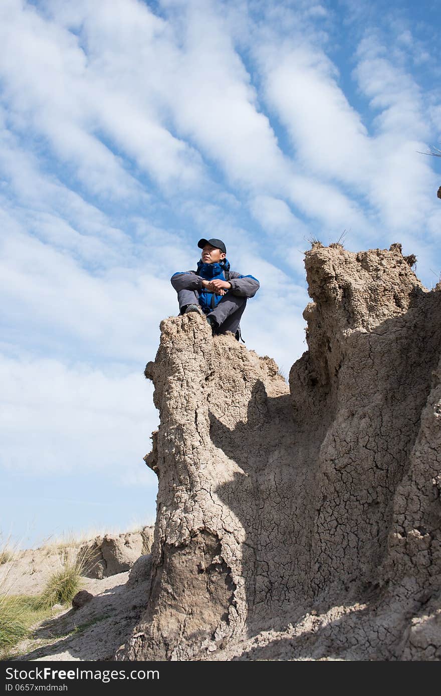 Sitting on a cliff resting hikers. Asian Youth. Sitting on a cliff resting hikers. Asian Youth