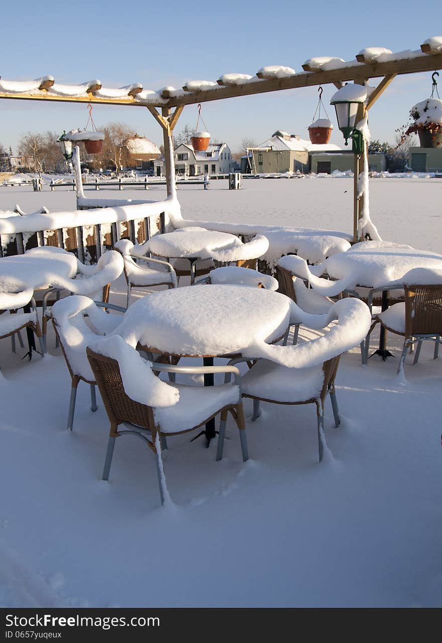 Snow covered furniture of a bar in the winter. Snow covered furniture of a bar in the winter