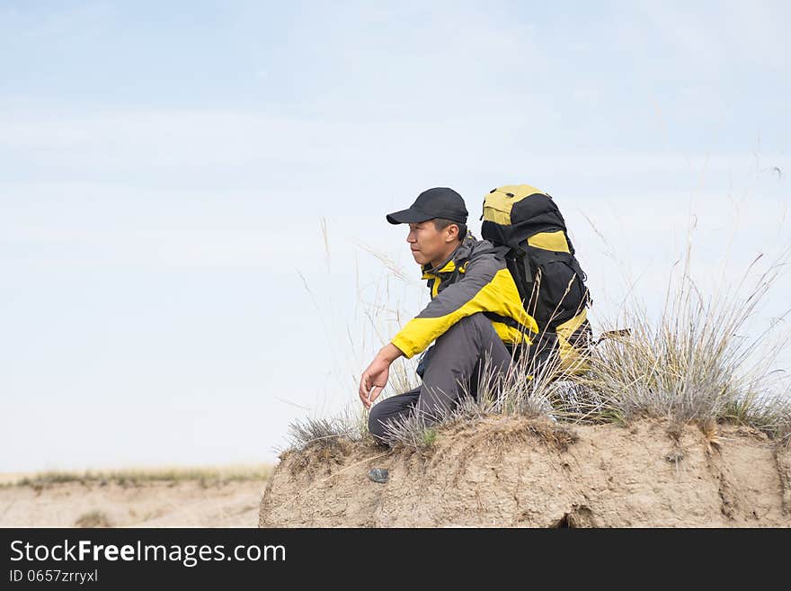 Hiker resting on the grass in autumn sunlight. Hiker resting on the grass in autumn sunlight