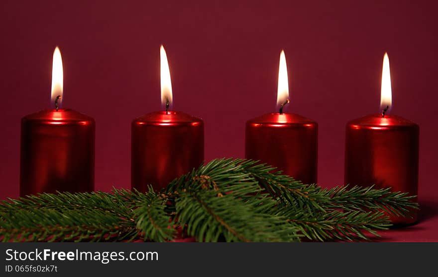 Four burning red candles on the red background