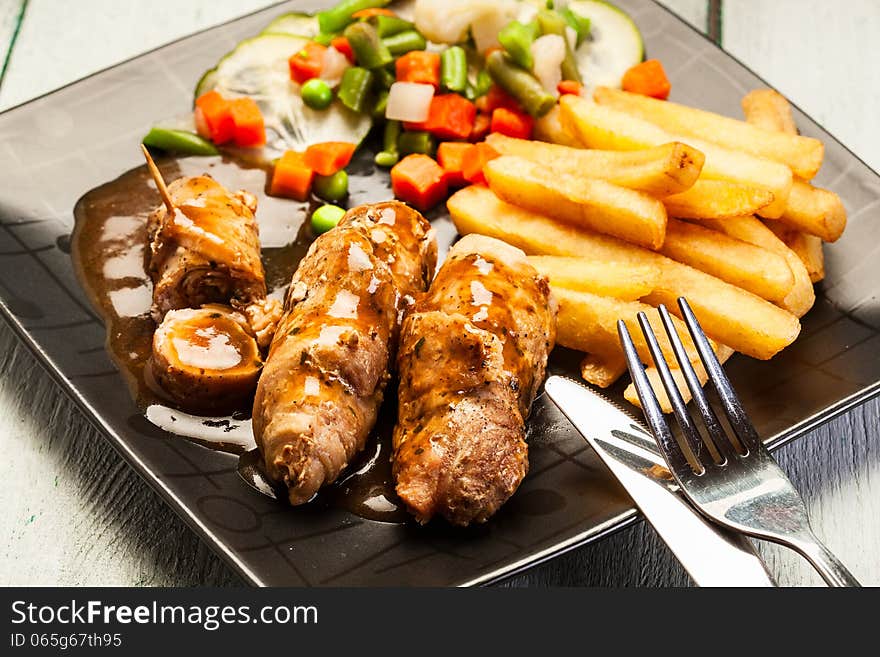 Beef rolls with french fries and begetables