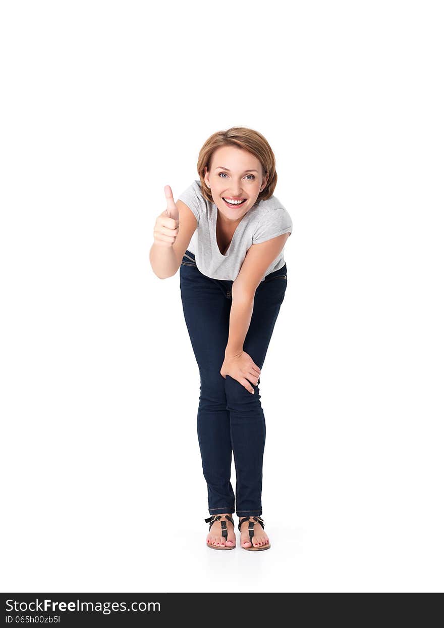 Full portrait of the beautiful happy woman stands at studio and showing thumbs up gesture on white background