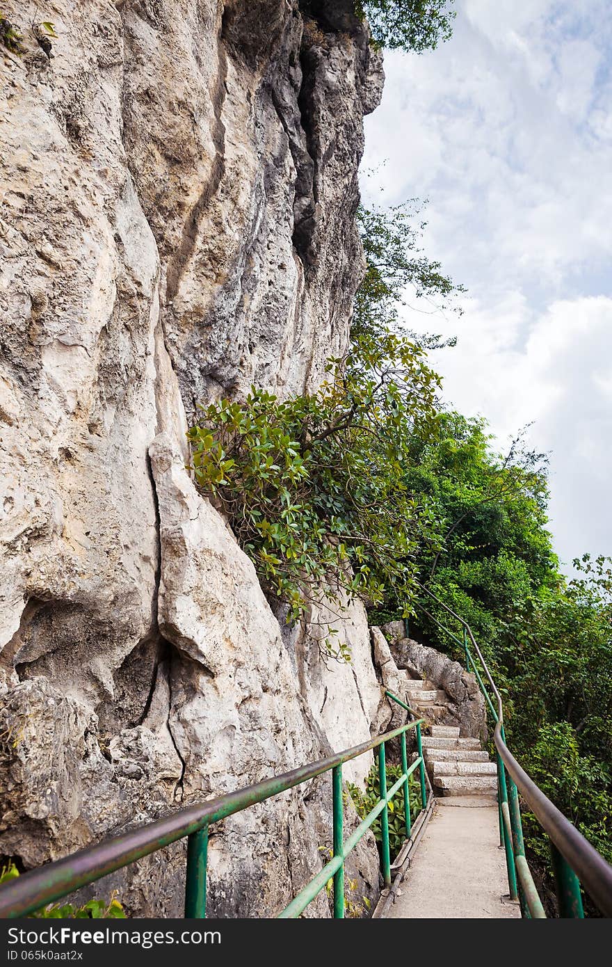 Small walking path by rocky hill. Small walking path by rocky hill