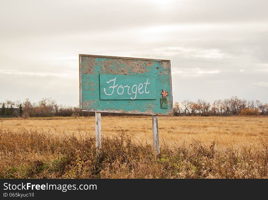 A green wood sign announcing Forget