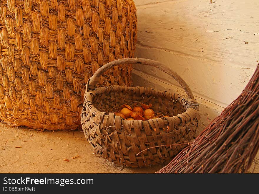 Inside of a wooden cottage: a wicker baskets and a broom