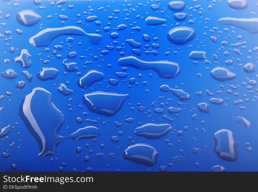 Close up image of water drops on blue surface. Close up image of water drops on blue surface