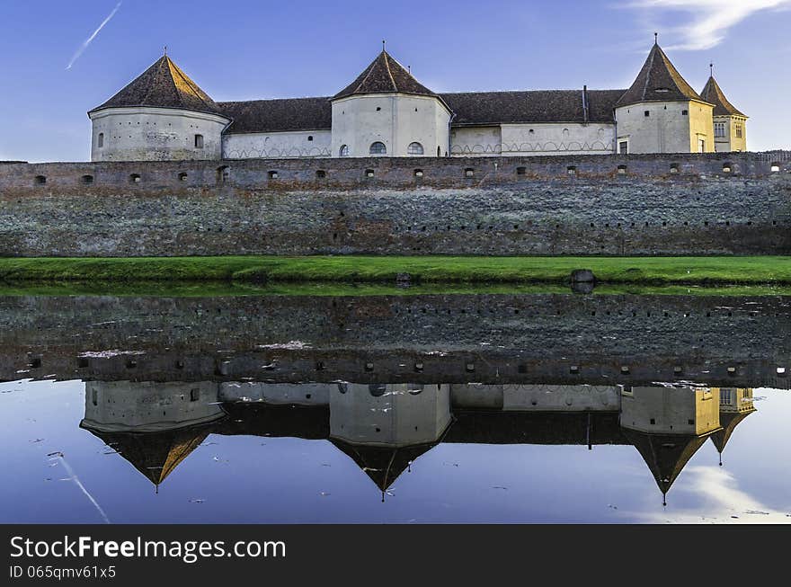 Sunset over the fortress of Fagaras and the swamp surrounding it. Sunset over the fortress of Fagaras and the swamp surrounding it