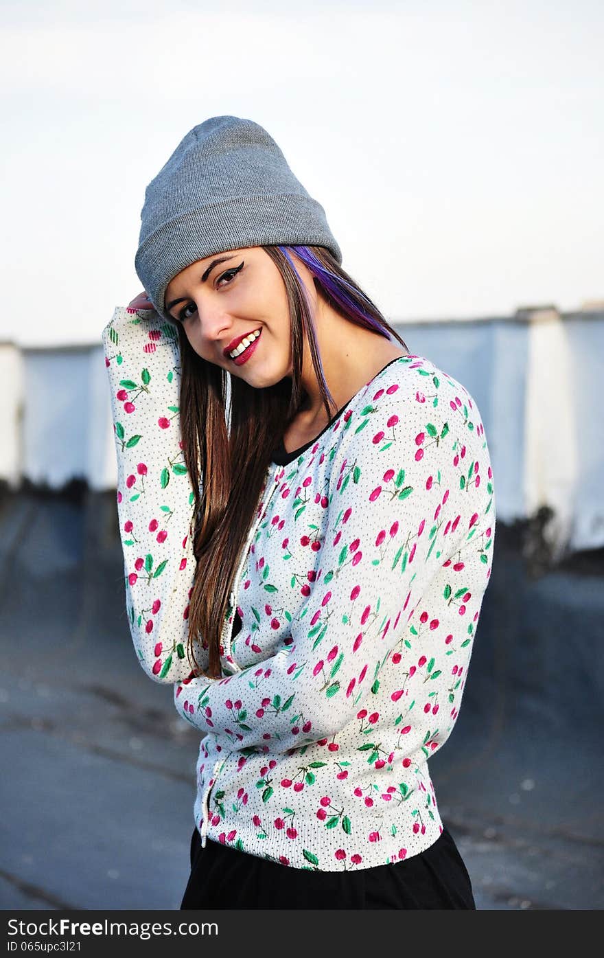 Portrait of an attractive young woman with long hair and cap on her head. Portrait of an attractive young woman with long hair and cap on her head.