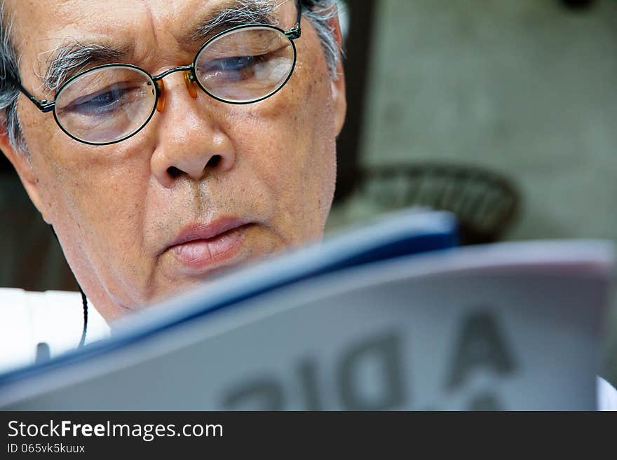 Senior man relaxing at home reading a book. Senior man relaxing at home reading a book