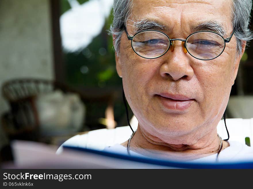 Senior man relaxing at home reading a book