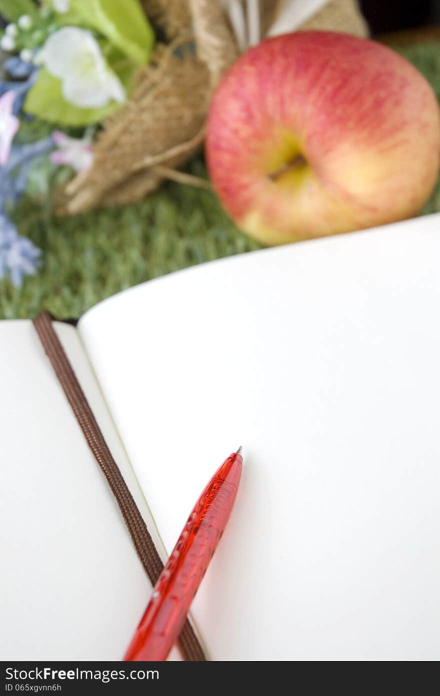 Blank white page with bouquet and fresh apple on grass. Blank white page with bouquet and fresh apple on grass