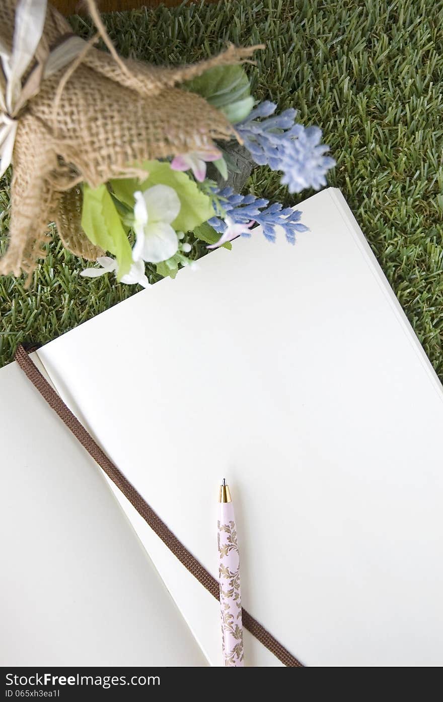 Blank paper page with bouquet flower on green grass