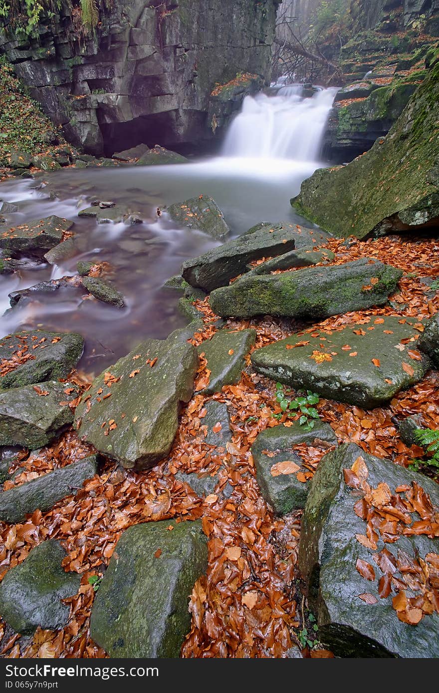 Autumn waterfall in a mountain stream