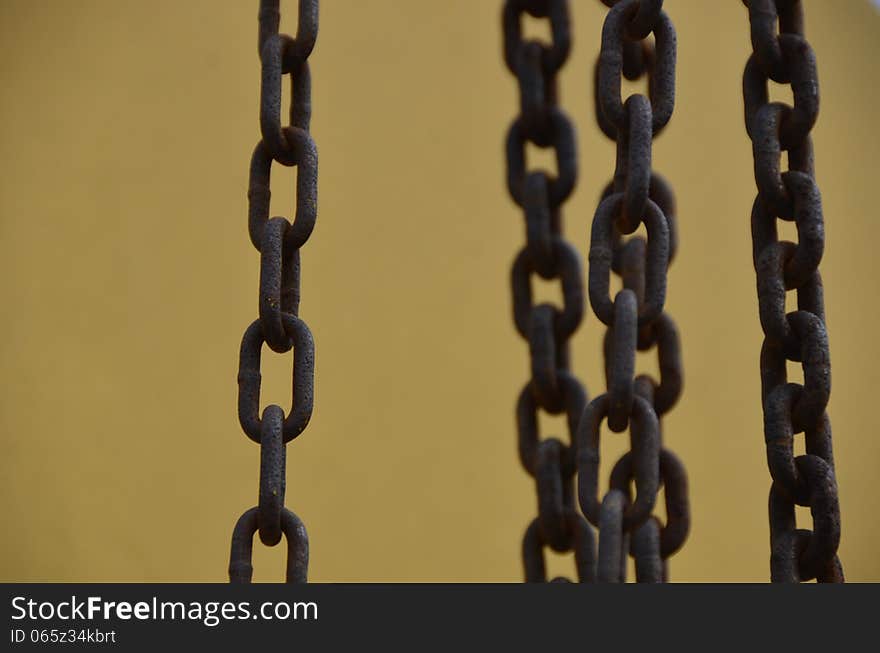 Five rusty chains on a yellow/gold metal background. Five rusty chains on a yellow/gold metal background