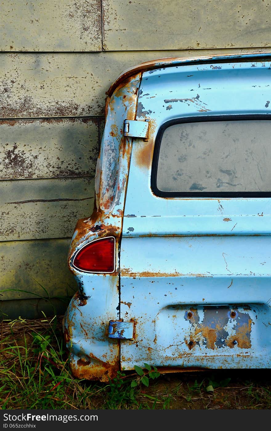 Rusted Blue van door leaning on wall